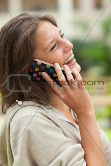 Side view of a cheerful woman using mobile phone