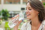 Close up side view of a young woman drinking water
