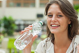 Close up portrait of a young woman drinking water