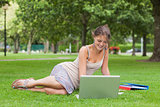 Student with laptop and books at the park