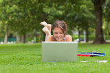 Female student with laptop and books at the park
