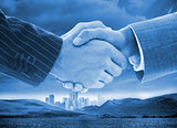 Business handshake on background of buildings and landscape