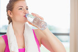Woman drinking water in fitness studio