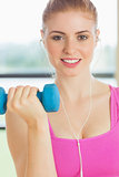 Woman exercising with dumbbells in fitness studio