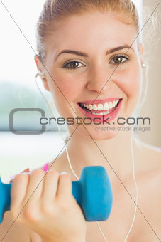 Close up portrait of a fit woman exercising with dumbbells