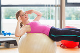 Fit woman working out with exercise ball in fitness studio