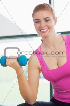 Portrait of a fit woman exercising with dumbbells