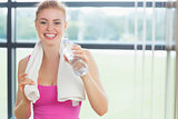 Woman with towel around neck holding water bottle