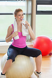 Fit woman on exercise ball with water bottle