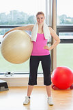 Fit beautiful young woman carrying exercise ball