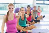 Portrait of fitness class and instructor gesturing thumbs up