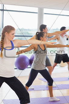 Sporty people stretching hands at yoga class in fitness studio