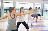 Sporty people stretching hands at yoga class