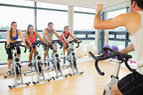 Man teaching spinning class to four people