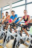 Four people working out at spinning class