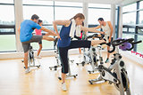 People warming up by exercise bikes in spinning class