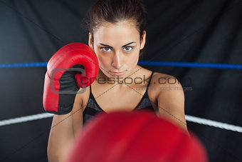 Beautiful woman in red boxing gloves in the ring