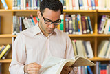 Concentrated mature student reading book in library