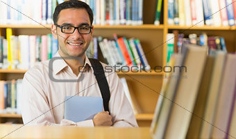 Smiling mature student with tablet PC in library