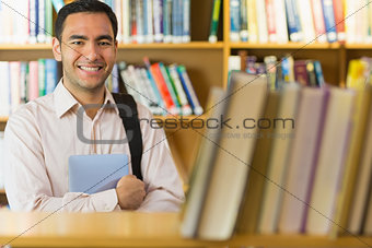 Smiling mature student with tablet PC in the library