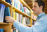 Mature student selecting book from shelf in library