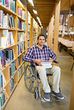 Man in wheelchair by bookshelf in the library