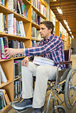 Man in wheelchair selecting book in library