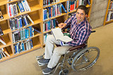 Man in wheelchair by bookshelf in the library