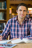Smiling mature male student at desk in the library