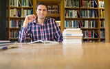 Smiling mature student studying at desk in the library