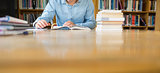 Mid section of a student studying at library desk