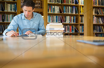 Serious mature student studying at library desk