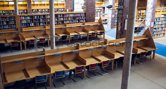 Empty seats and bookshelves at college library