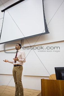 Male teacher against projection screen in lecture hall
