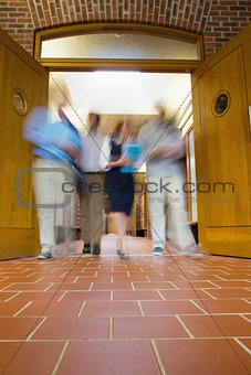Blurred people walking through open doors