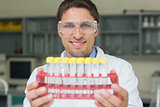 Smiling male researcher with test tubes in the lab