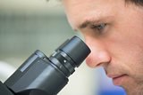 Close up of a scientific researcher using microscope