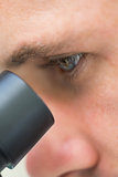 Extreme Close up of a scientific researcher using microscope