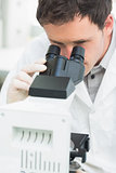 Male scientific researcher using microscope in laboratory
