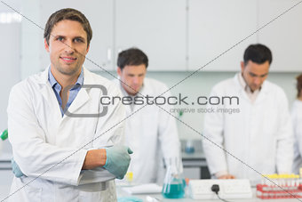 Smiling scientist with colleagues at work in the lab