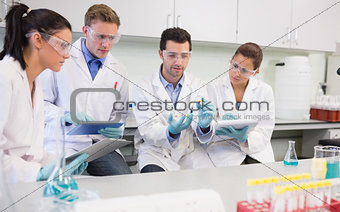 Scientists with tablet PC working on an experiment at lab