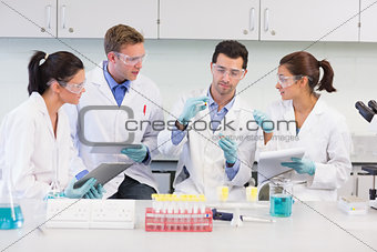 Scientists with tablet PC working on experiment at lab