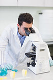 Male scientific researcher using microscope in lab