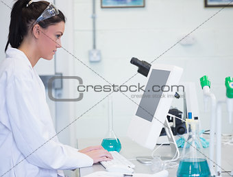 Young female researcher using computer in lab