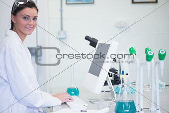 Young female researcher using computer in lab