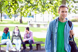 Portrait of college boy with blurred students in park