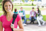 College girl smiling with blurred students in park