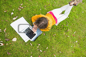 Female student using tablet PC in the lawn