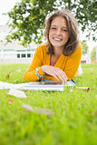 Smiling female student using tablet PC in lawn