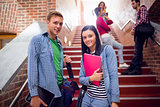 Couple with students behind on stairs in the college
